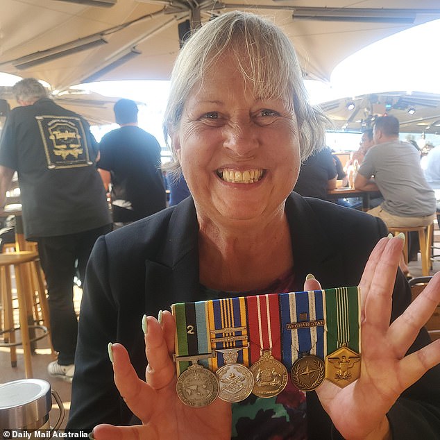 Cath Harvey, a 30-year-old Navy veteran, shows the medals she wore that attracted the royal couple