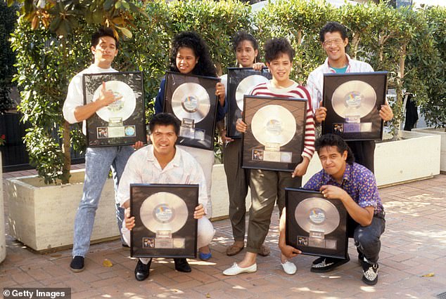 The Jets, made up of siblings from Tonga, pose for a portrait with plaques commemorating a 1986 sales milestone in Los Angeles, California