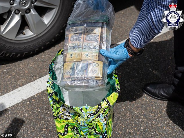 A search for another vehicle led to the discovery of approximately $100,000 in cash (pictured), prepaid SIM cards, a phone and an iPad