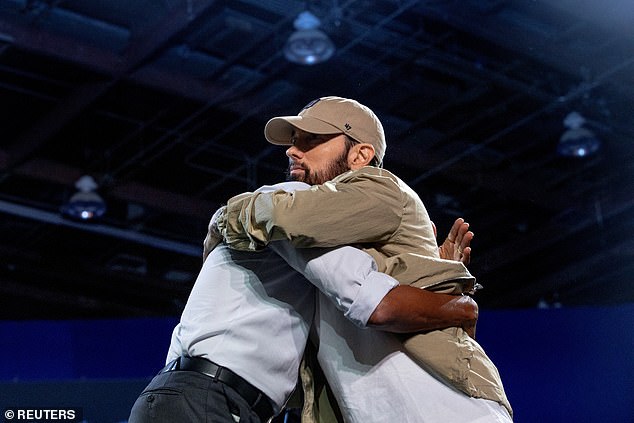 Former President Barack Obama (left) hugs Eminem (right) after the Detroit rapper introduced the former president Tuesday night during a rally in support of Vice President Kamala Harris in the Motor City