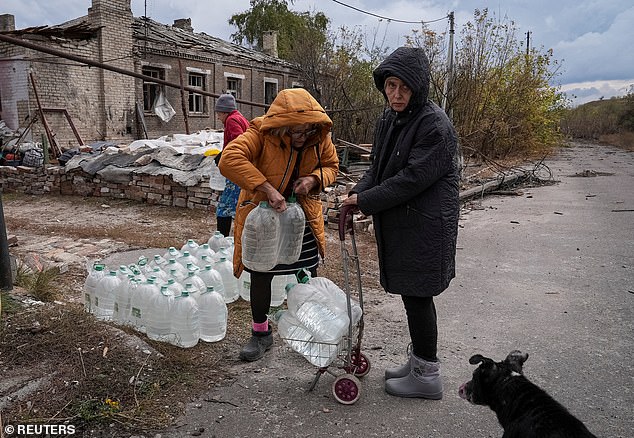 Residents take bottles of drinking water from humanitarian aid supplied by volunteers, during the conflict between Russia and Ukraine, in the frontline city of Khasiv Yar in Donetsk region, Ukraine, October 16, 2024