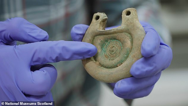 One of the objects from the Peebles Hoard is being examined by an expert