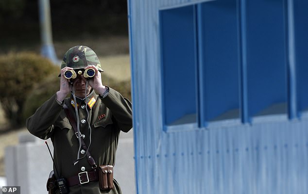 Ms X said: 'There were numerous examples of girls, who could be considered daughters or younger sisters, being used as sexual playthings [in the detention camps]' (file image of a North Korean soldier looking through binoculars)