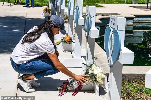 Meghan lays flowers at a makeshift memorial in Uvalde, Texas, two days after a gunman killed 19 students and two teachers and injured 17 others in May 2022