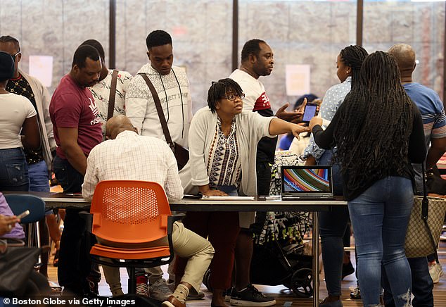 Haitian migrants are assisted by staff from the Immigrant Families Services Institute in Boston