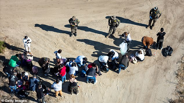 U.S. Border Patrol agents round up a group of Colombian asylum seekers after crossing from Mexico