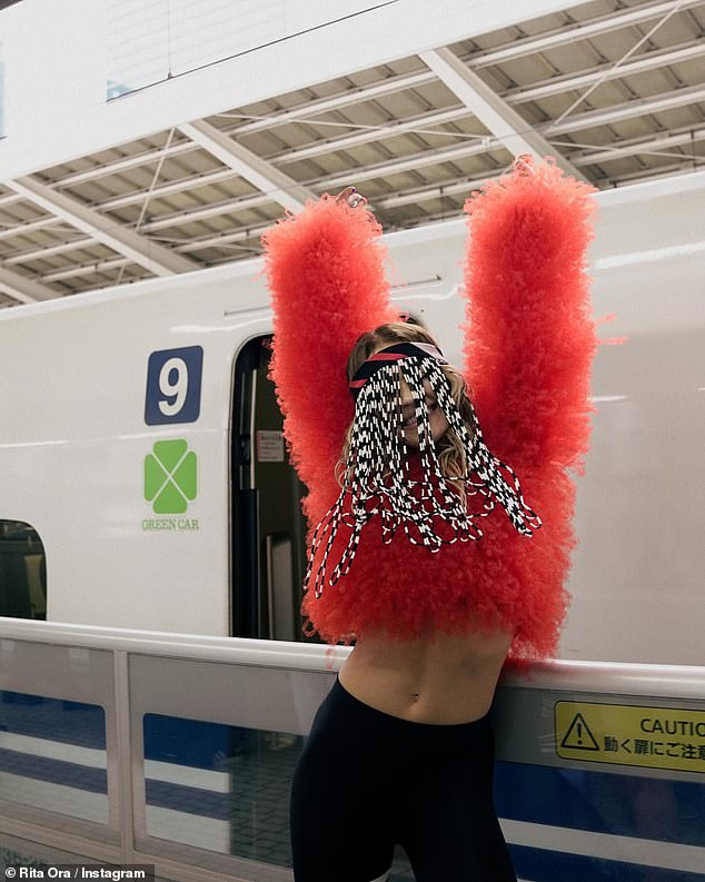 Rita hopped on public transport in Osaka wearing a fluffy red crop top and black leggings