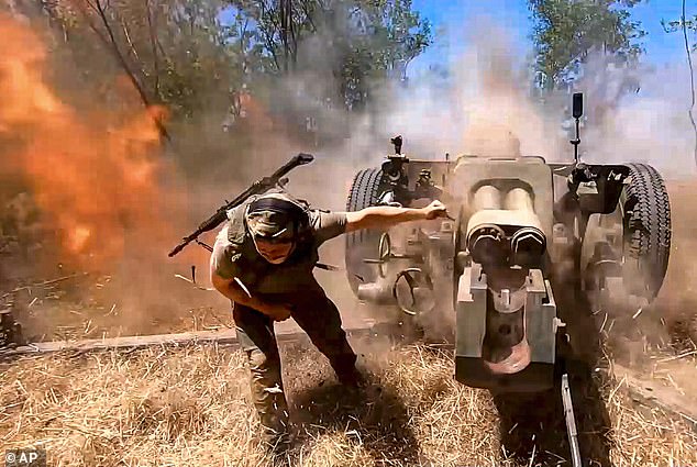 A Russian soldier fires from the D-30 howitzer towards Ukrainian positions at a secret location in Ukraine