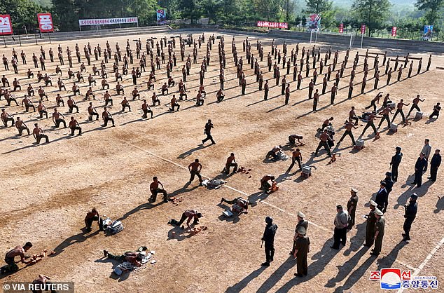 North Korean soldiers are seen smashing concrete blocks during a demonstration for Kim and senior officials