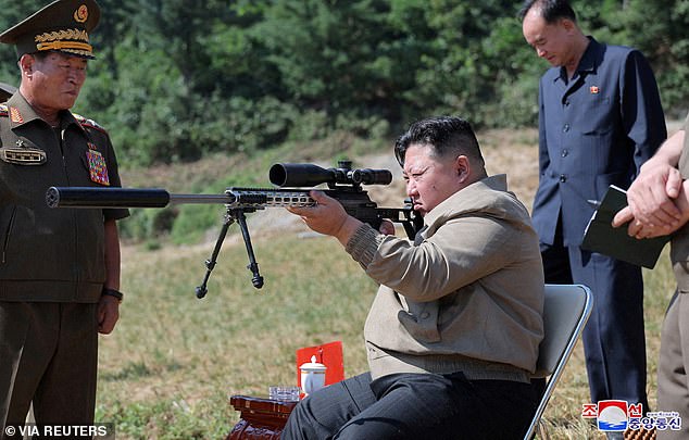 North Korean leader Kim Jong Un points a gun while visiting a training base