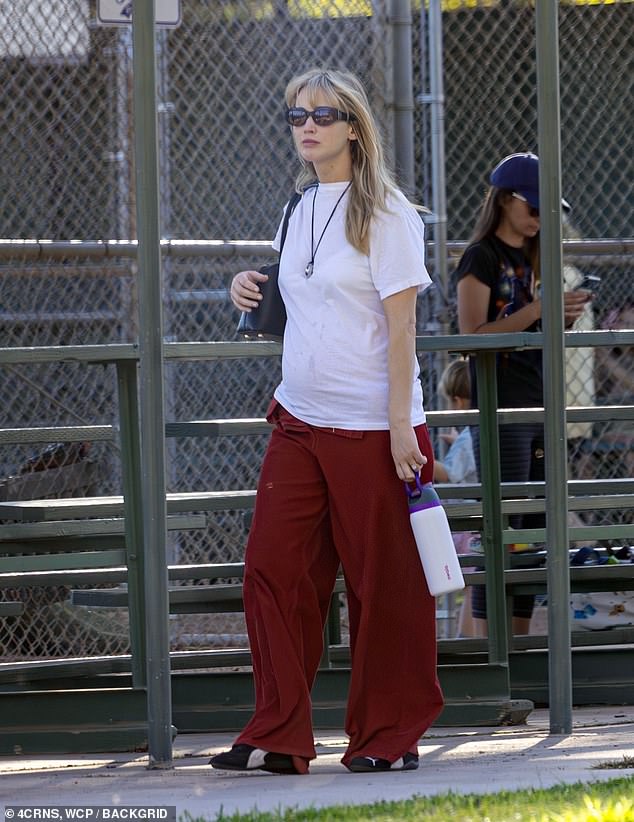 The No Hard Feelings star, 34, cuts a casual figure in a loose white T-shirt and red trousers. Jennifer wore her blonde hair down and parted it in the middle with curtain bangs