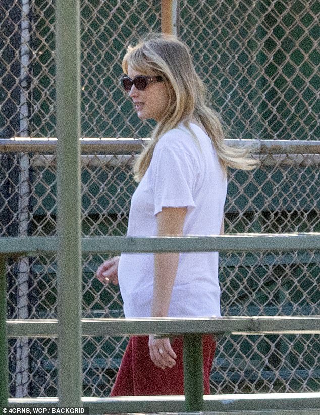 She carried a square black handbag and wore sunglasses on the sunny day in Southern California. Her burgeoning baby bump was barely visible as she turned to the side