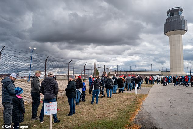 MAGA fans lined up to see Trump at an event guarded by law enforcement officers carrying long guns