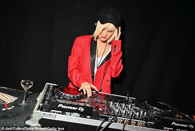 Laura Whitmore was also spotted spinning the decks for guests and stood out in a bright red blazer and thigh-high PVC boots