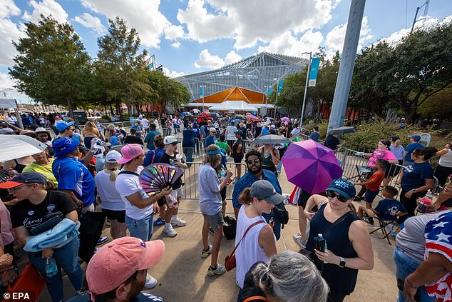 Harris supporters held fans and umbrellas as they waited in the sun to attend the vice president's rally in Houston on Oct. 25