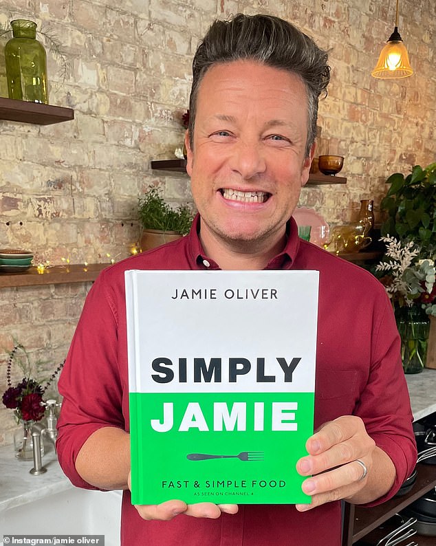 In a candid new interview, Jamie said his food heroes were 'terrible' to him after he became a TV chef and best-selling author. Pictured: Jamie, who has sold more than 50 million books, shows off the cover of his latest book Simply Jamie