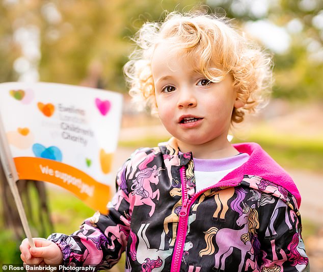 Molly cheers for her mother and waves a small flag in support of ELCH