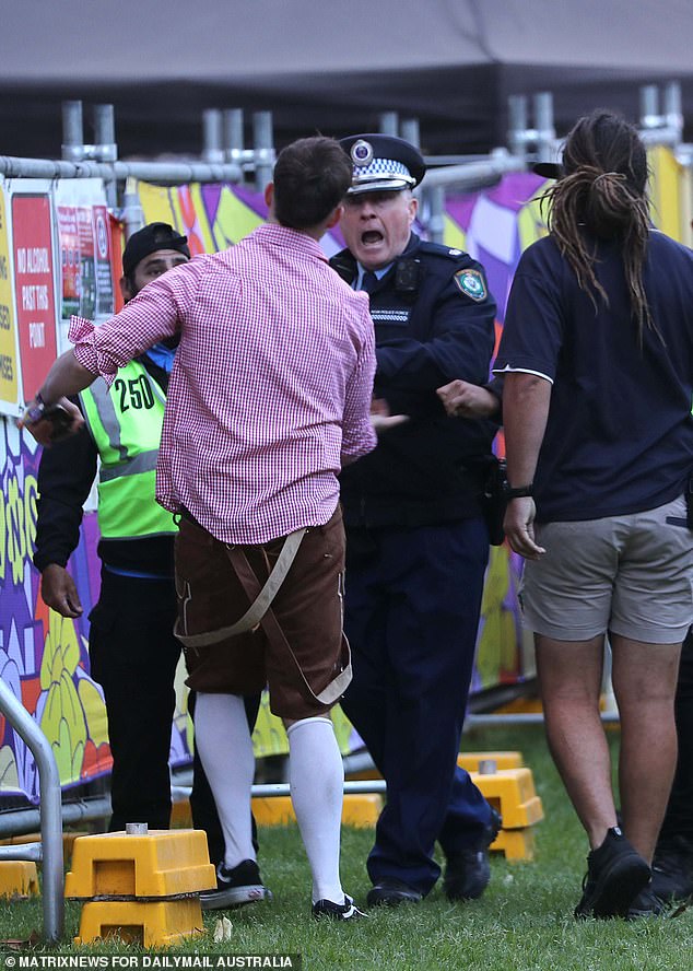 One reveler receives his marching orders from a police officer