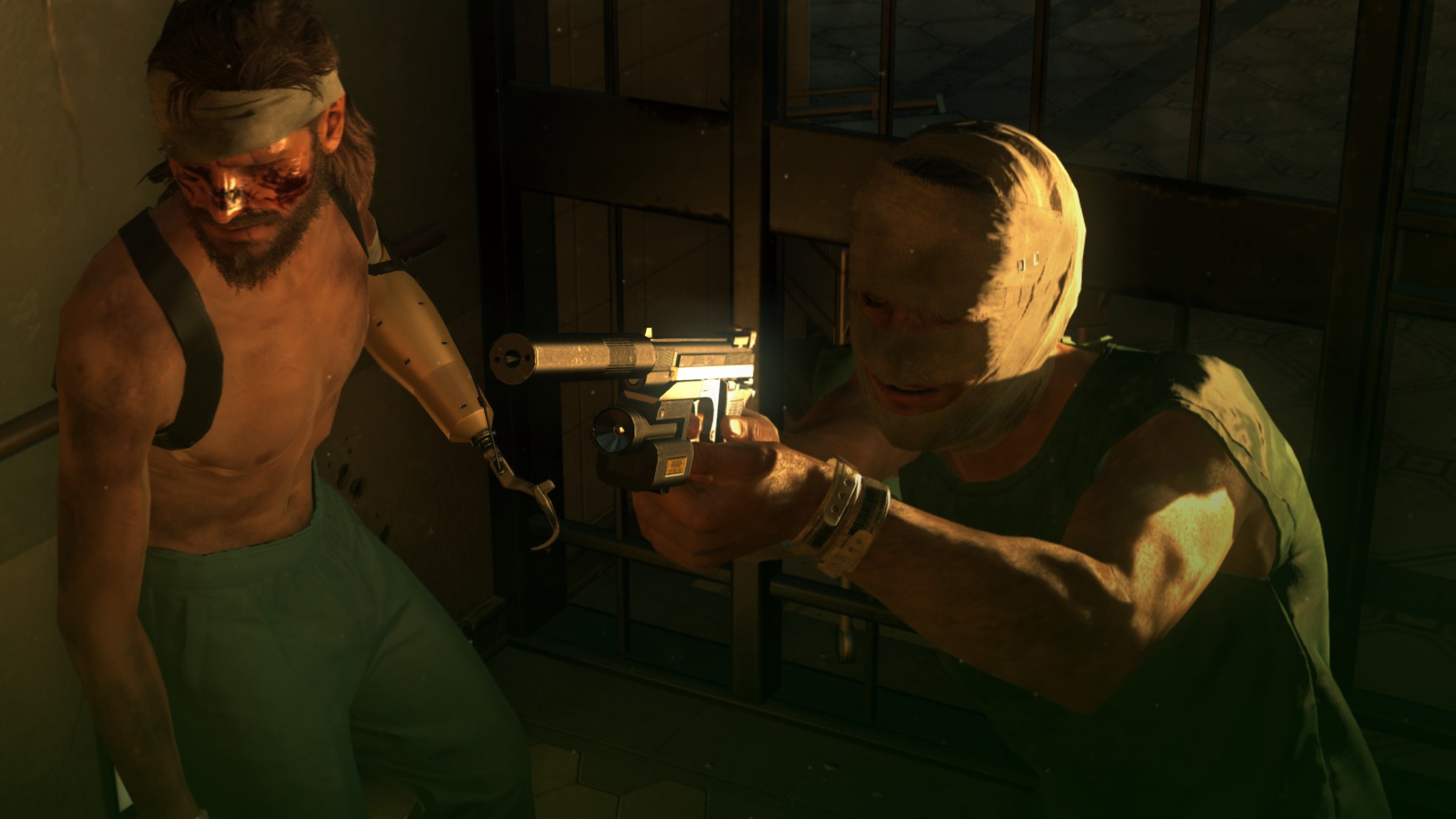 A shirtless man with a prosthetic arm standing next to a man with a bandaged face and pointing a silenced gun in Metal Gear Solid 5: The Phantom Pain.