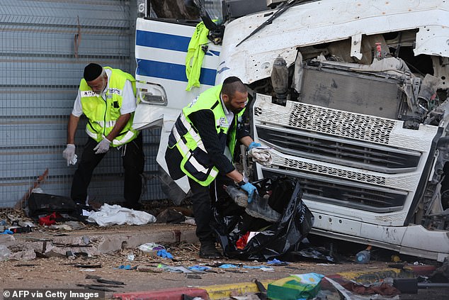 Israeli aid workers clear the scene after a driver rammed his truck into a crowd of people at a bus stop in Ramat Hasharon, north of Tel Aviv, on October 27, 2024.