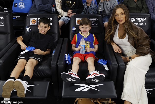 The fashionista wore a low-cut white dress that hugged her curves as she took her courtside seat for the match between Melbourne United and the Cairns Taipans NBL at John Cain Arena.