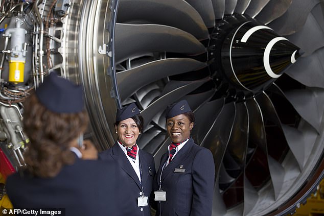 Aviation crew pose for a photo in front of a Rolls Royce Trent 1000 turbofan engine during an event marking the arrival of a British Airways Airbus A380 at Heathrow Airport in London on July 4, 2013