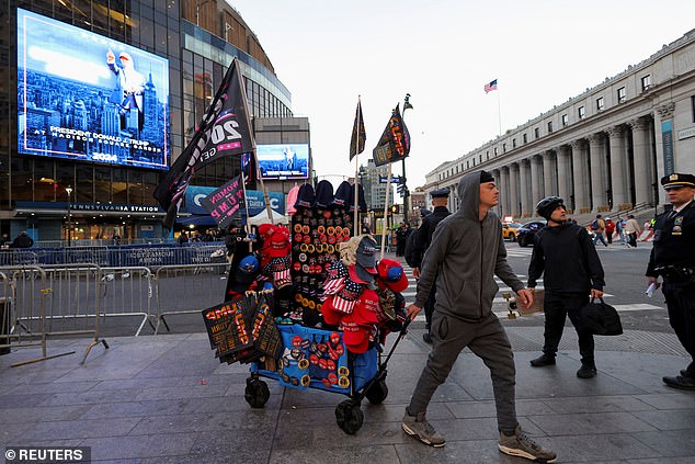 A man is seen wheeling around a cart filled to the brim with Trump merchandise outside MSG