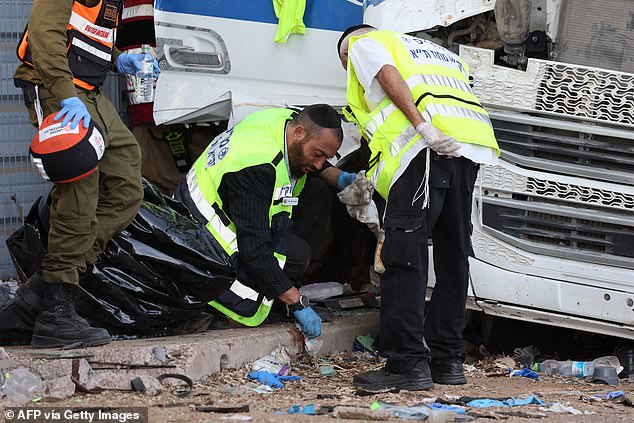 Israeli aid workers clear the scene after a driver rammed his truck into a crowd of people at a bus stop in Ramat Hasharon, north of Tel Aviv, on October 27, 2024.