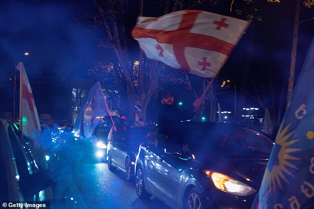 Supporters of the Georgian Dream Party celebrate the exit poll results outside the new Georgian Dream headquarters during Georgian Election Day on October 26, 2024 in Tbilisi, Georgia