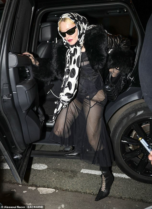 Madonna wore a pair of black lace-up knee-high boots and packed her belongings into a matching handbag