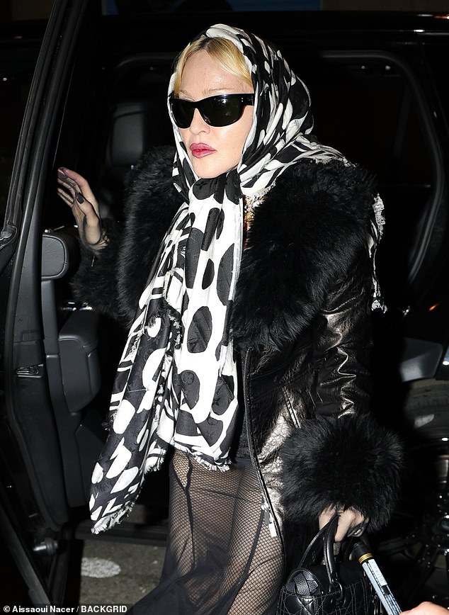 She wore a striking white and black spotted headscarf tied around her head as she left her hotel