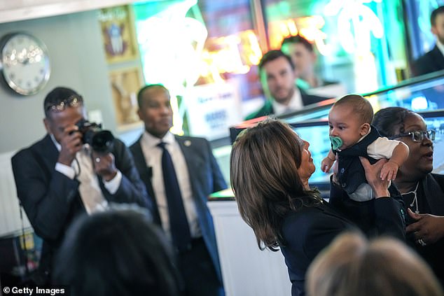 Kamala Harris hugs a baby at Freddy & Tony's Restaurant, a local Puerto Rican restaurant in Philly