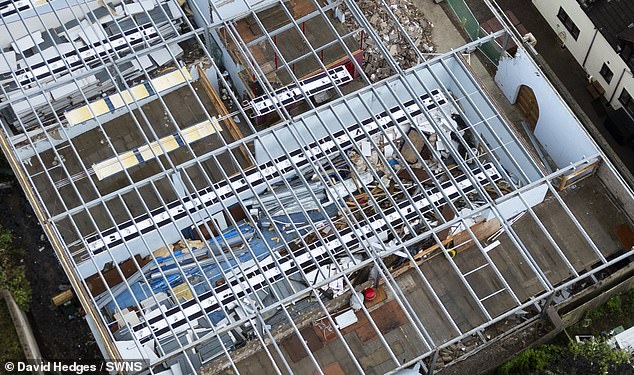 Aerial photos taken in July showed the roof had been torn off and debris was piled high in the rooms inside