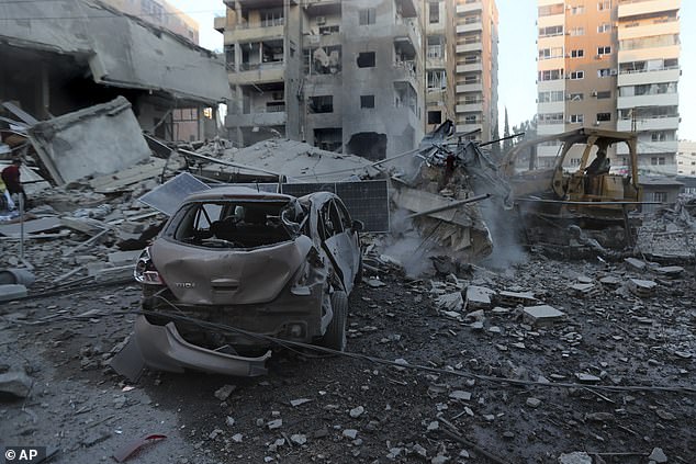 A rescue worker uses a bulldozer to remove rubble from destroyed buildings hit by Israeli airstrikes in Tyre, Lebanon, Monday, October 28, 2024