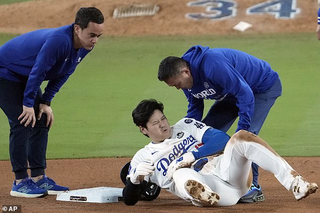 Shohei Ohtani, center, reacts after being injured trying to steal second place