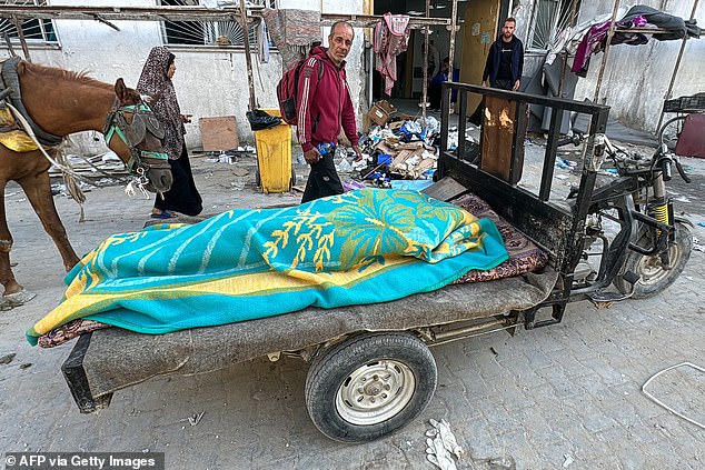 A body lies covered in a blanket on a cart outside the Kamal Adwan Hospital in Beit Lahia in the northern Gaza Strip on October 28, 2024