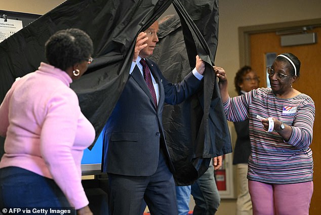 After casting his vote, the president pulls open the black curtain around the ballot box