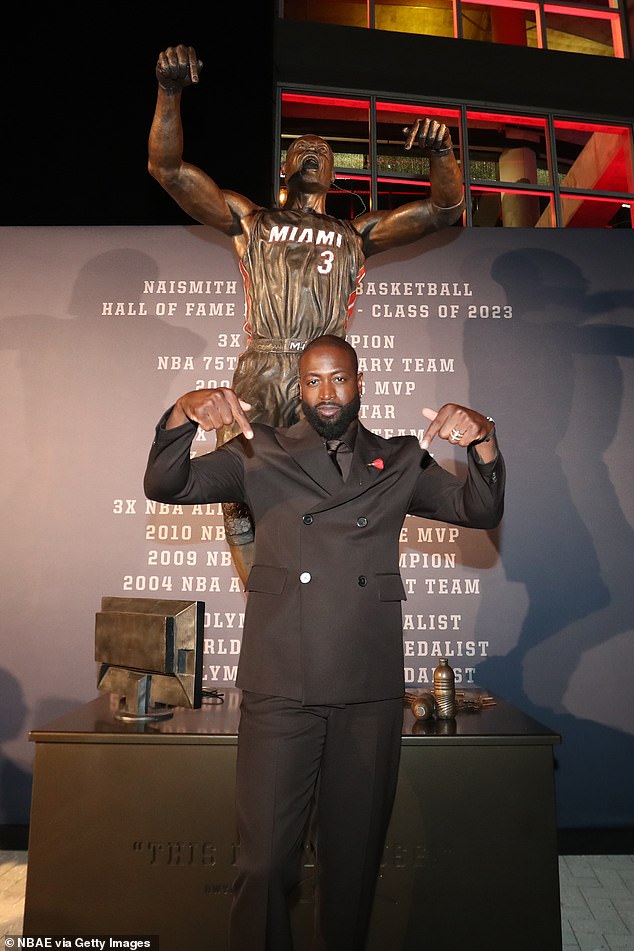 Wade poses next to his statue after Sunday's unveiling ceremony outside Kaseya Center