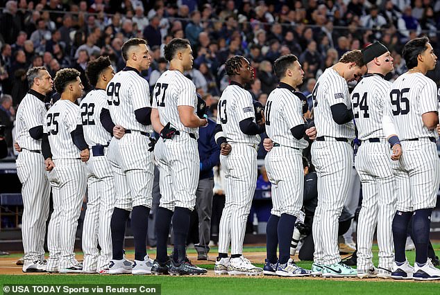 The Yankees players line up to sing the national anthem before World Series Game 3