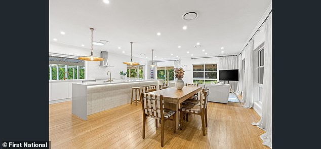 A sleek, modern kitchen has a walk-in pantry, induction hob, stone worktops and a spacious large island