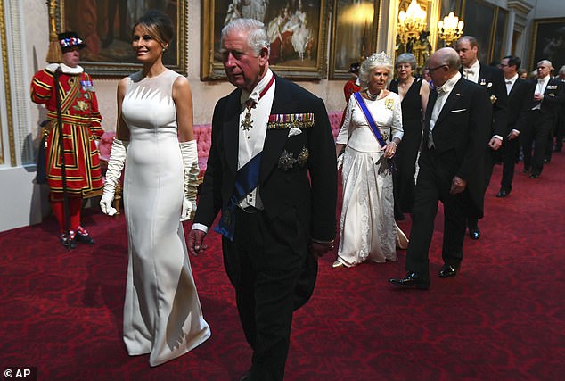 Pictured: First Lady Melania Trump walks next to Prince Charles as they enter the ballroom for the state banquet to welcome the US president