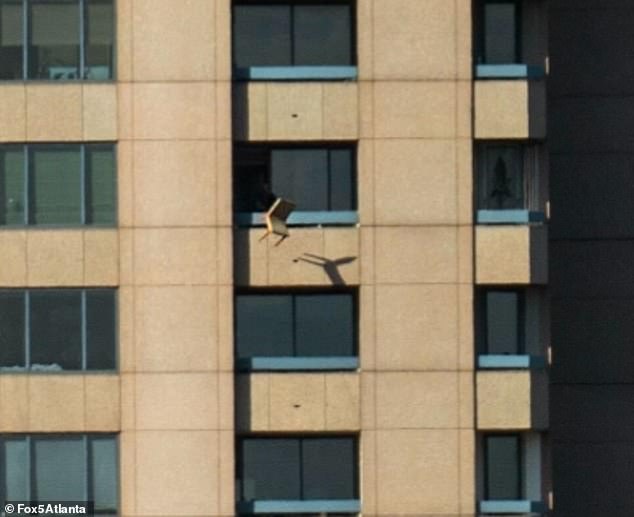 A chair is seen being thrown from the balcony of the 53-storey building