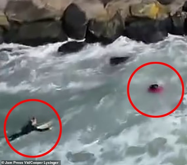 As he approached the man, he was able to grab him and drag him to the safety of his own surfboard