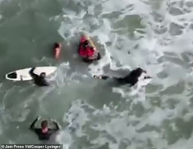 The footage then showed other surfers paddling towards Lysinger in an attempt to help