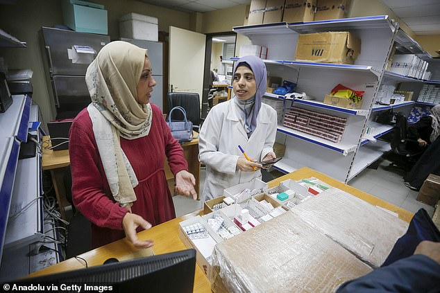 Two doctors provide medicines at the UNRWA centre. Labor and Tory loyalists questioned whether ministers were using all available options to force Israel's hand