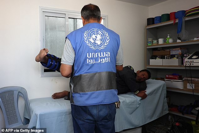 An UNRWA physiotherapist helps a Palestinian man at the Japanese health center in Khan Yunis, Gaza