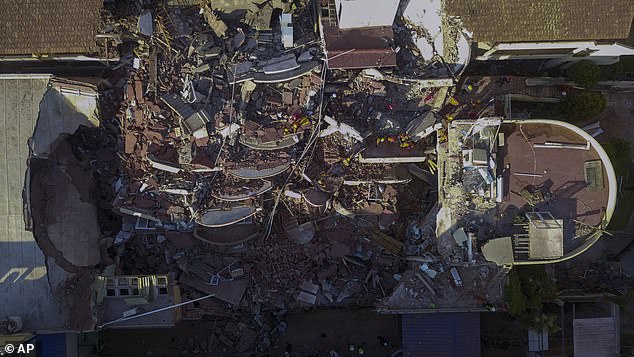 Firefighters and rescuers search for survivors in the rubble of the partially collapsed Dubrovnik Hotel in Villa Gesell, Argentina