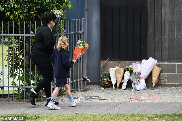 A student is seen leaving flowers at the accident site on Wednesday