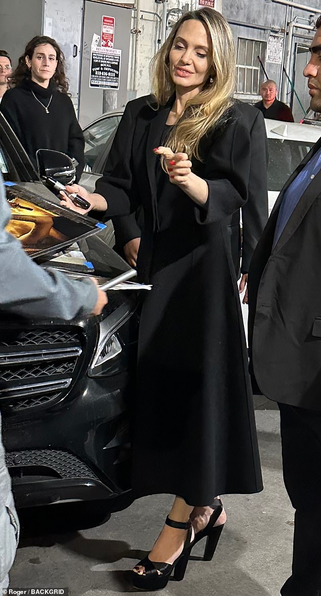 Angelina had a big smile on her face as she strolled to the entrance of the theater and took the time to sign autographs for the fans waiting outside