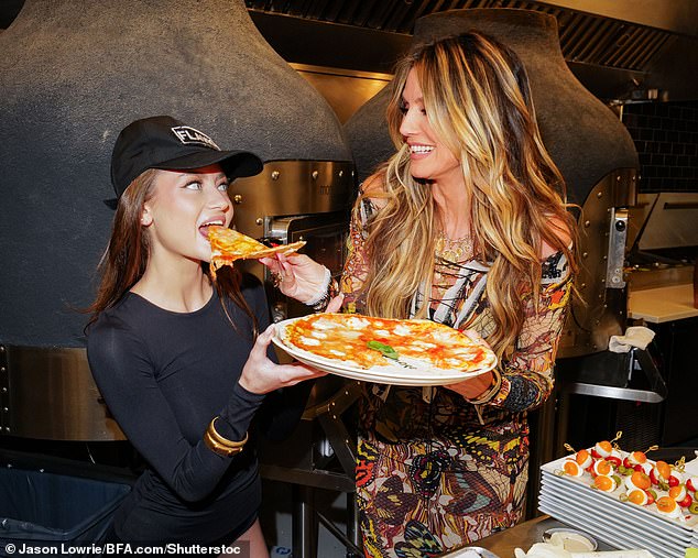 At one point, Heidi playfully fed a slice of yeast-free pizza to her nepo mini-me, who she hired to appear on the upcoming 20th season of Germany's Next Topmodel.